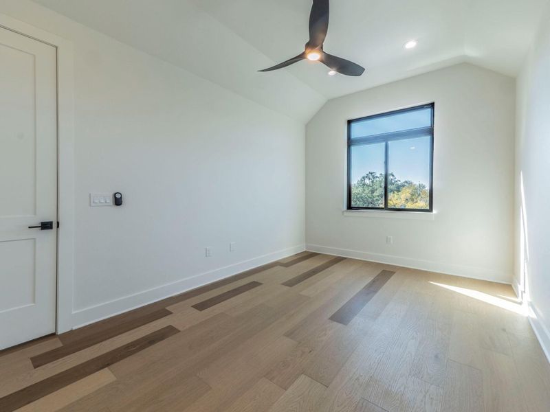 Spare room with lofted ceiling, light wood-type flooring, and recessed lighting Spare room with lofted ceiling, light wood-type flooring, and recessed lighting