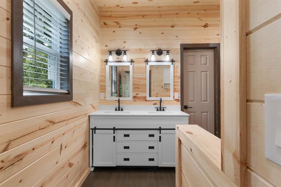 Bathroom featuring wooden walls and a sink Bathroom featuring wooden walls and a sink