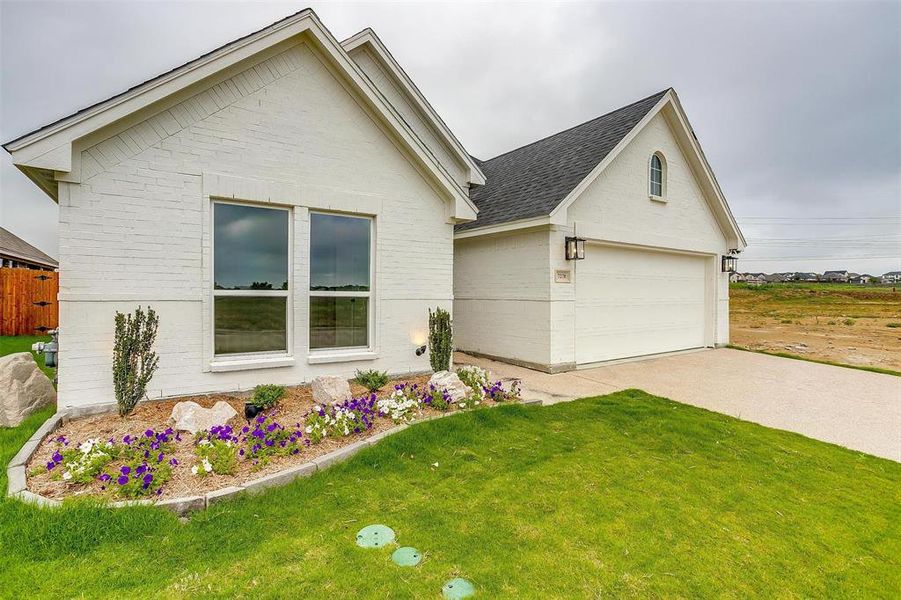 View of front of house featuring a front lawn and a garage