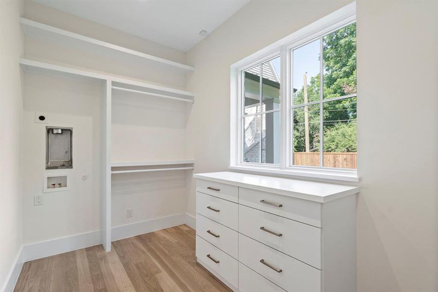 Spacious closet with light hardwood / wood-style flooring