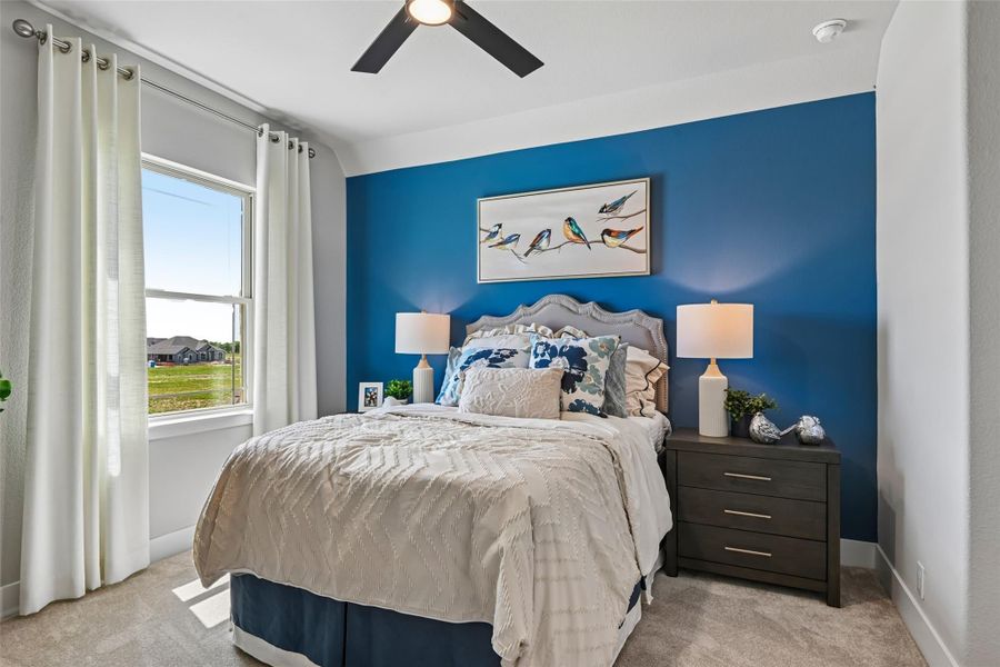 Bedroom with blue accent wall, ceiling fan, queen bed, and two nightstands with lamps Bedroom with blue accent wall, ceiling fan, queen bed, and two nightstands with lamps