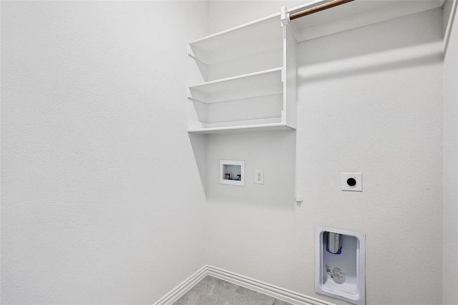 Laundry area with hookup for a gas dryer, hookup for an electric dryer, tile patterned flooring, and washer hookup