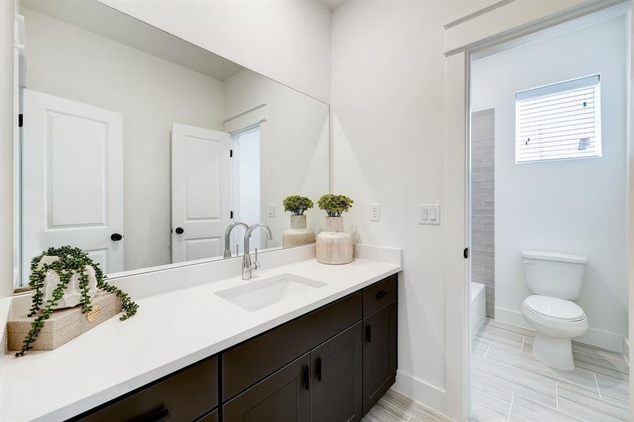 Modern Elegance: This bathroom boasts sleek fixtures, dual vanities, and a spacious walk-in shower, all adorned with contemporary finishes for a serene retreat.