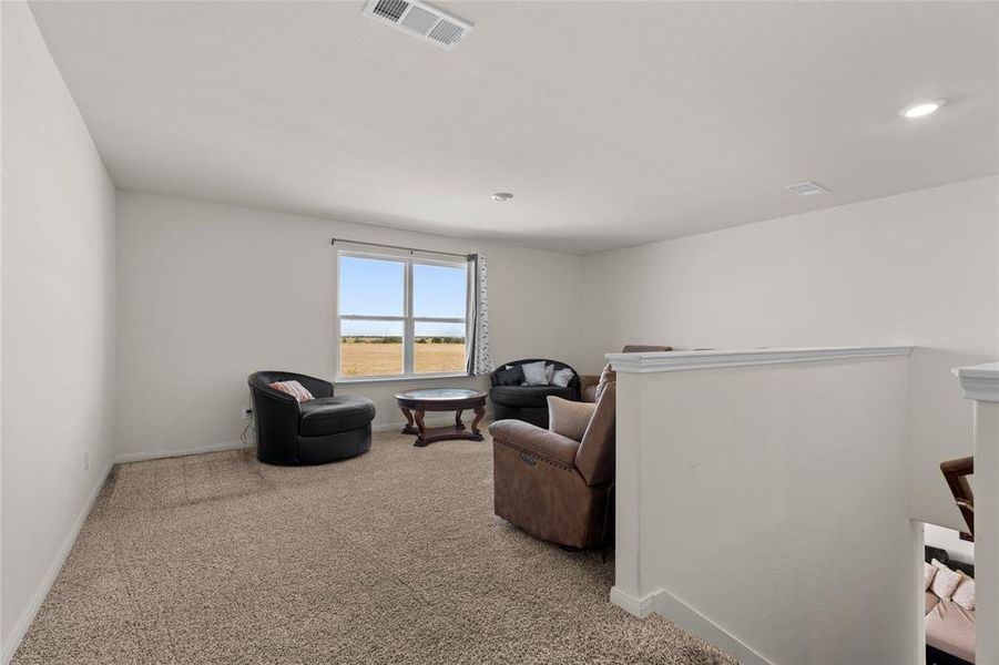 Sitting room with light carpet and an upstairs landing