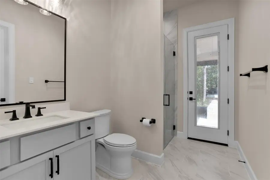 The full ensuite bath features a walk-in shower with direct access to the backyard—making it perfect for guests or as a convenient pool bath.