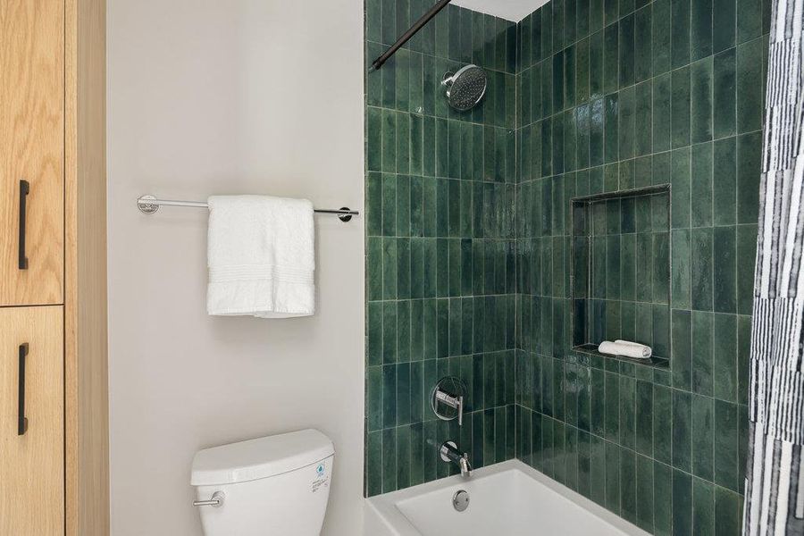 Bathroom featuring shower / washtub combination and toilet Bathroom featuring shower / washtub combination and toilet
