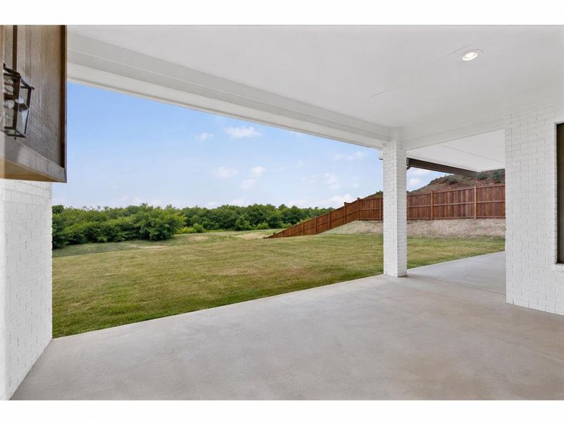 Expansive covered patio with concrete flooring, white brick columns, and recessed lighting Expansive covered patio with concrete flooring, white brick columns, and recessed lighting