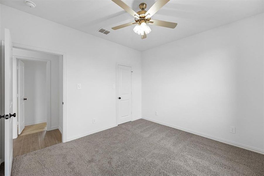 Unfurnished room with light colored carpet and ceiling fan