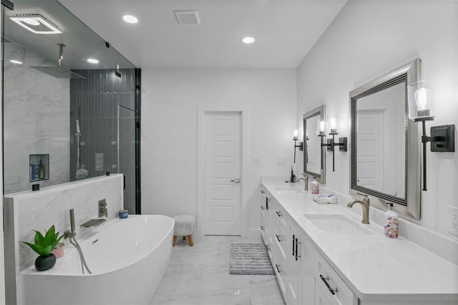 Full bath featuring a tile shower, double vanity, a soaking tub, recessed lighting, and light marble finish floors Full bath featuring a tile shower, double vanity, a soaking tub, recessed lighting, and light marble finish floors