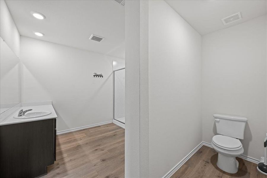 Full bathroom featuring light wood-type flooring, vanity, a shower with door, and recessed lighting Full bathroom featuring light wood-type flooring, vanity, a shower with door, and recessed lighting