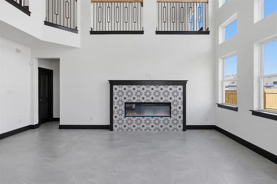 Towering ceilings and a modern tiled fireplace create a dramatic focal point in this room. Towering ceilings and a modern tiled fireplace create a dramatic focal point in this room.