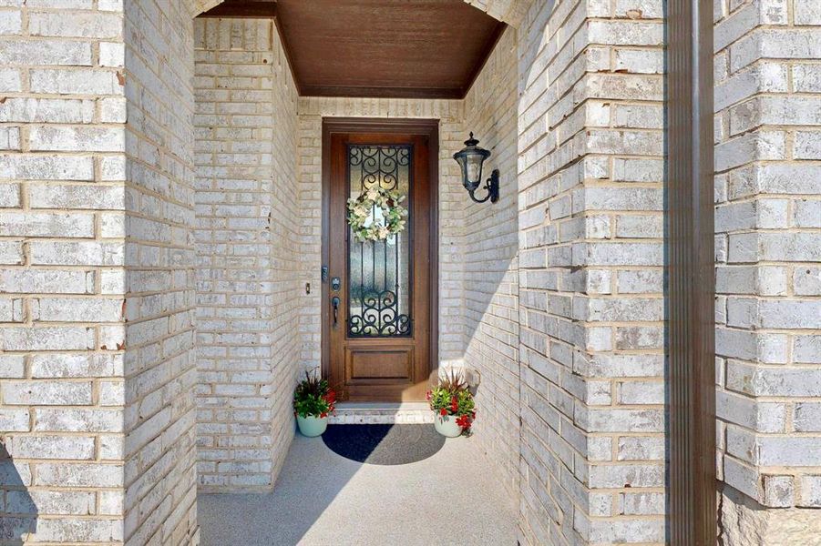 View of exterior entry with brick siding