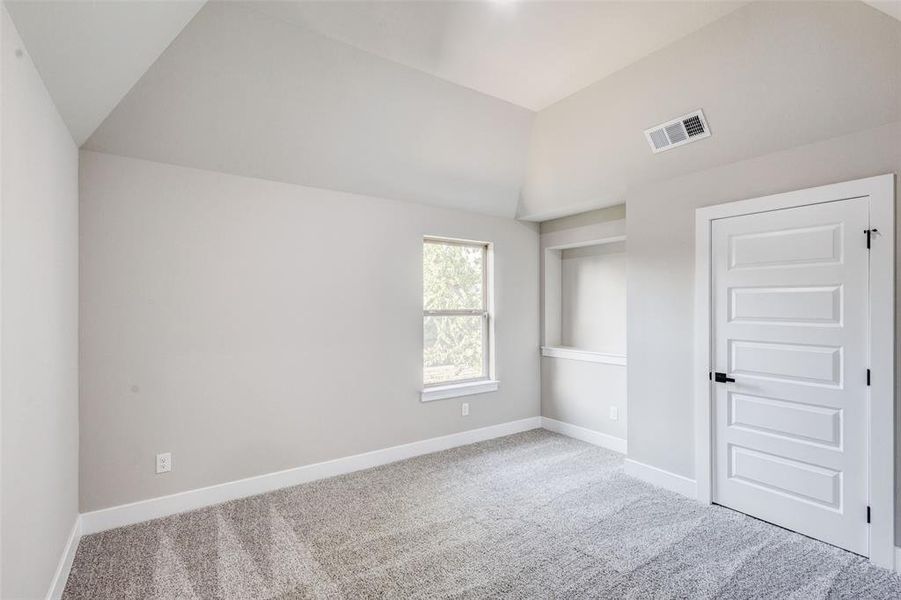Bedroom featuring lofted ceiling and carpet floors