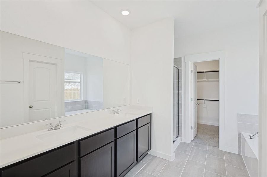 Bathroom with tile patterned floors, vanity, and independent shower and bath