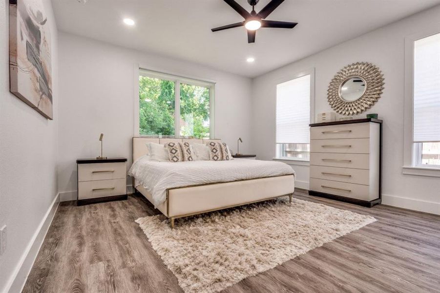 Bedroom featuring wood finished floors, multiple windows, recessed lighting, and ceiling fan