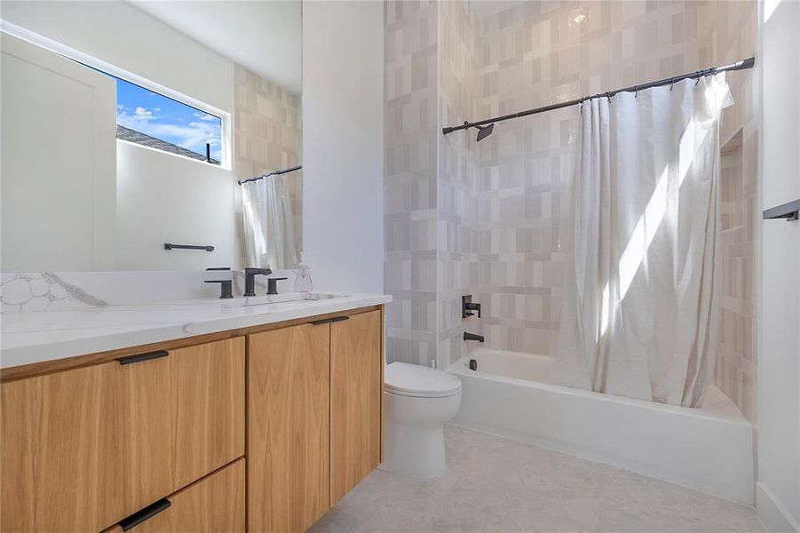 Full bathroom featuring toilet, vanity, and shower / bath combination with curtain