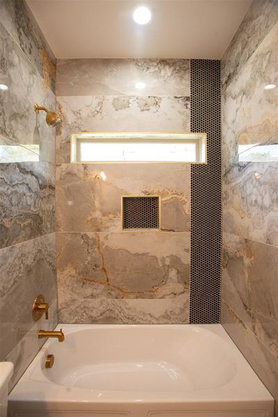 Bathroom with plenty of natural light and tiled shower / bath