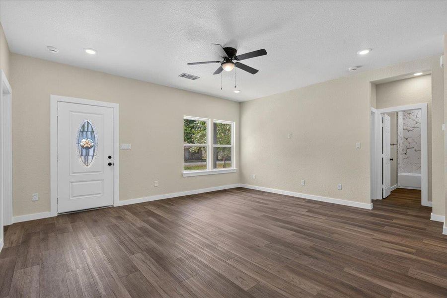 Rich wood floors and recessed lighting anchor this open entryway and central living area. Rich wood floors and recessed lighting anchor this open entryway and central living area.