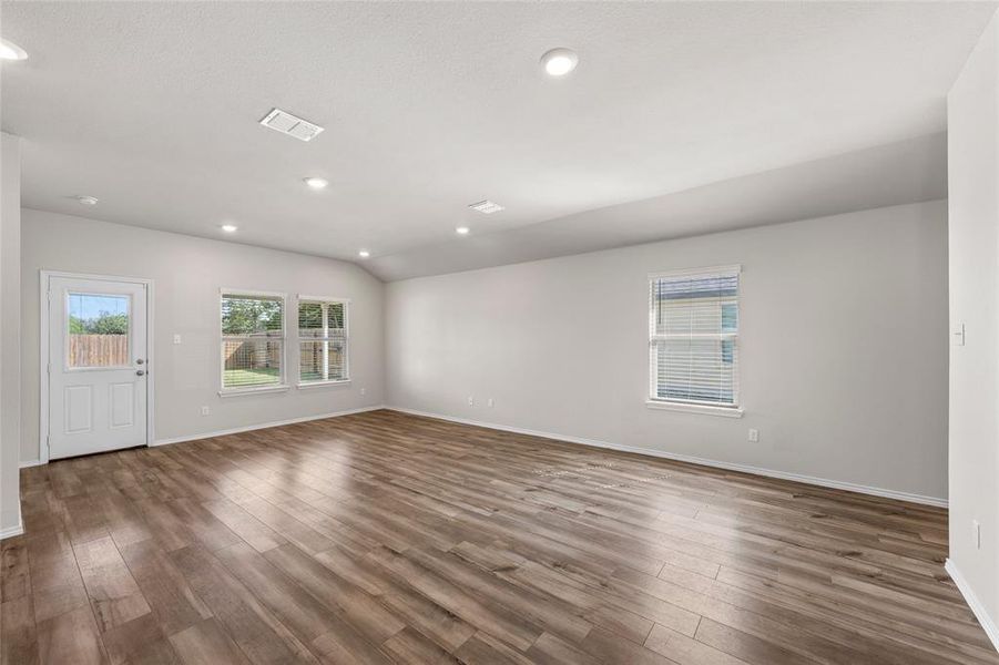 Spare room featuring wood finished floors, recessed lighting, and vaulted ceiling Spare room featuring wood finished floors, recessed lighting, and vaulted ceiling