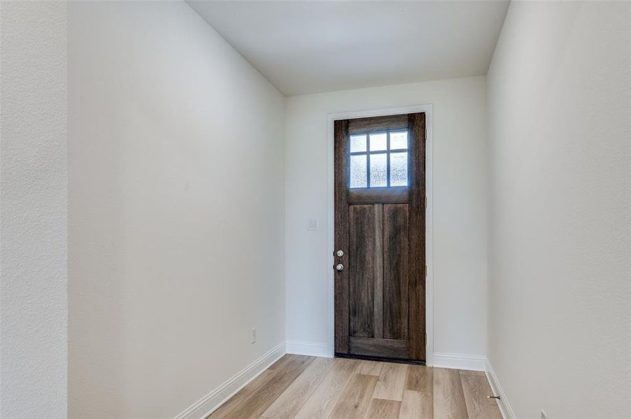 Foyer entrance featuring light wood finished floors and baseboards