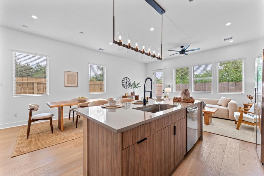 Striking and modern kitchen island serves as the centerpiece of this open-concept culinary space, featuring a waterfall quartz countertop that flows seamlessly down one side for a sculptural, high-end look. The island is framed by minimalist cabinetry in matte finishes, paired with bold pendant lighting that adds a touch of sophistication. Integrated bar seating invites casual dining and conversation, while the clean lines and neutral palette enhance the island’s sleek aesthetic. Striking and modern kitchen island serves as the centerpiece of this open-concept culinary space, featuring a waterfall quartz countertop that flows seamlessly down one side for a sculptural, high-end look. The island is framed by minimalist cabinetry in matte finishes, paired with bold pendant lighting that adds a touch of sophistication. Integrated bar seating invites casual dining and conversation, while the clean lines and neutral palette enhance the island’s sleek aesthetic.