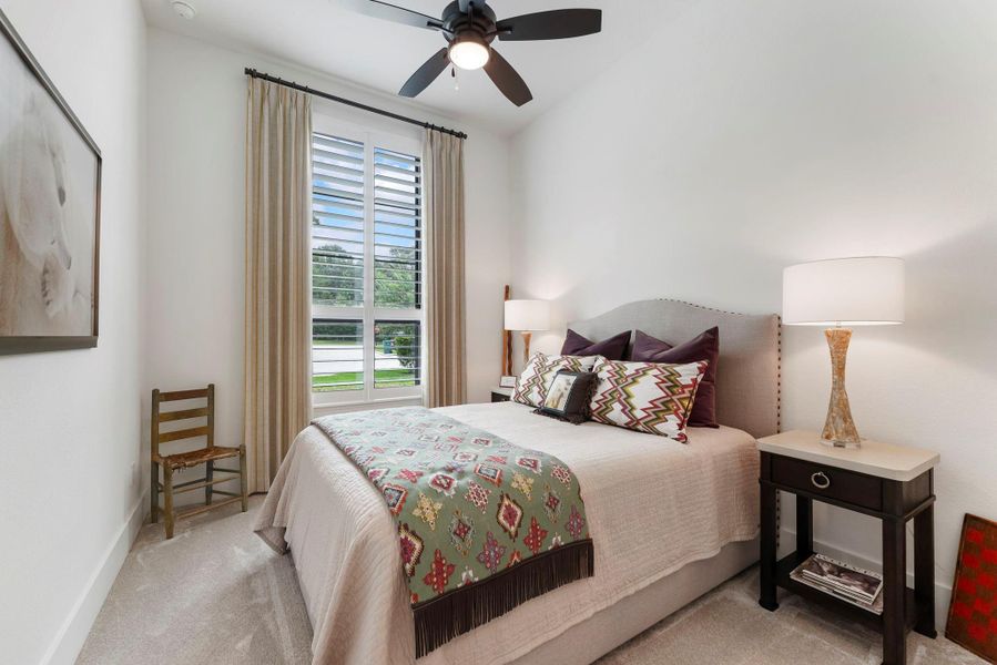 Another secondary bedroom provides a bright, private retreat with plantation shutters and custom window coverings.