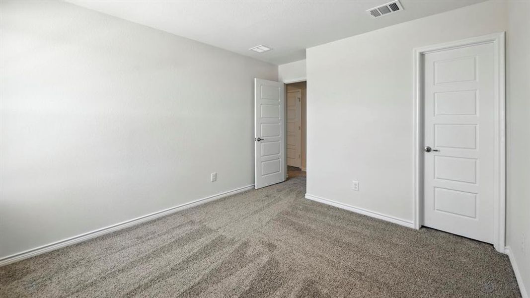 Unfurnished bedroom with carpet flooring and baseboards