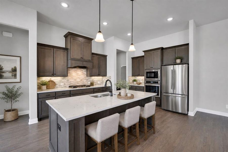 Designer kitchen featuring quartz countertops, oversized island, built-in oven and microwave, gas cooktop, and abundant cabinetry. Virtually staged