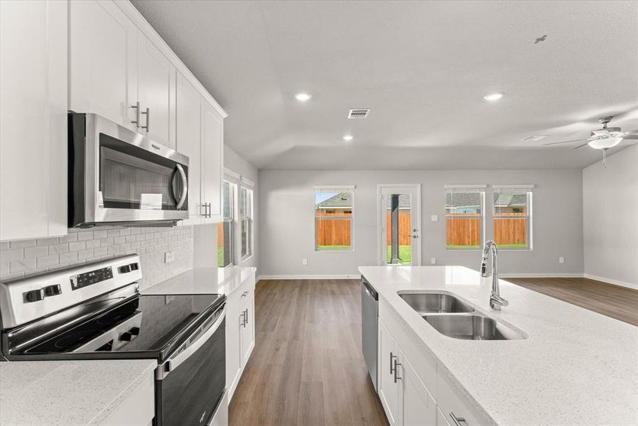 Kitchen featuring ceiling fan, appliances with stainless steel finishes, and large center island