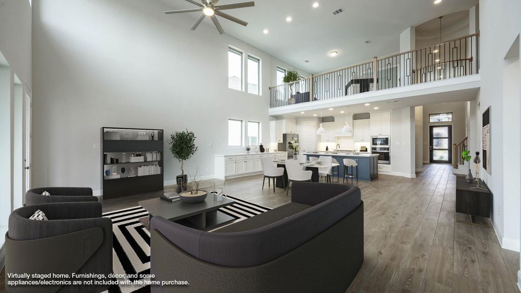 Living area with recessed lighting, light wood-type flooring, ceiling fan, and a high ceiling