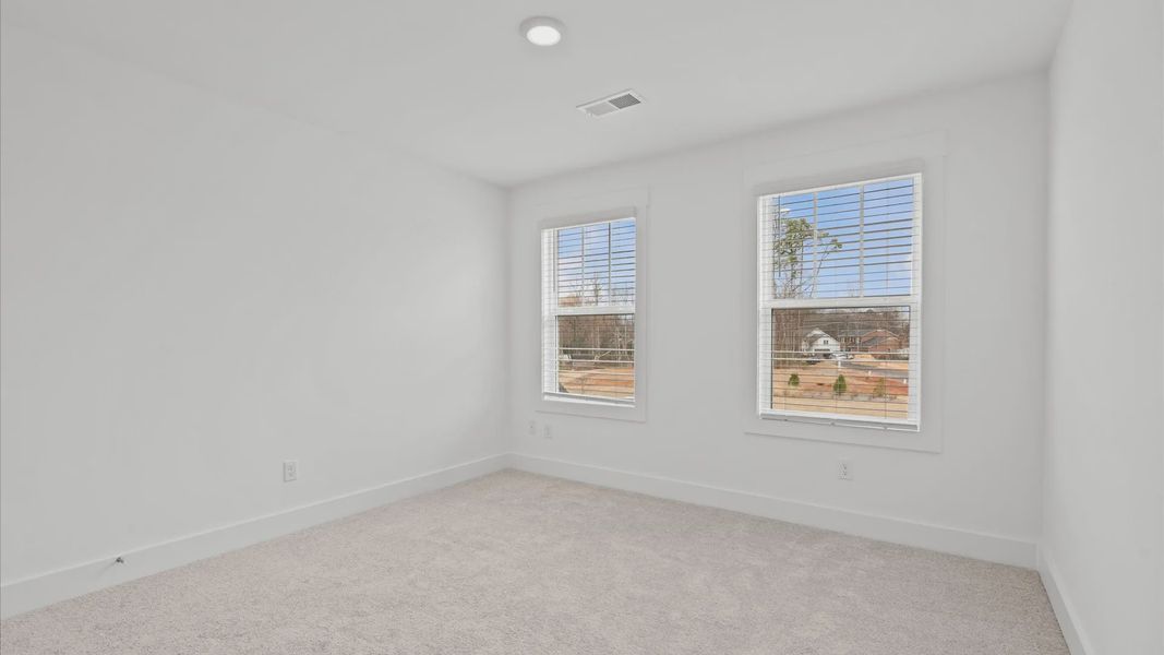 Elegant bedroom retreat featuring soft carpeting and a thoughtfully designed walk-in closet located at Pelham Crossing