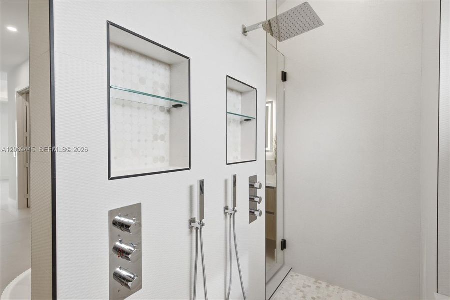 Oversized glass-enclosed shower offers a rainfall showerhead, dual handheld fixtures and multiple body jets. Oversized glass-enclosed shower offers a rainfall showerhead, dual handheld fixtures and multiple body jets.
