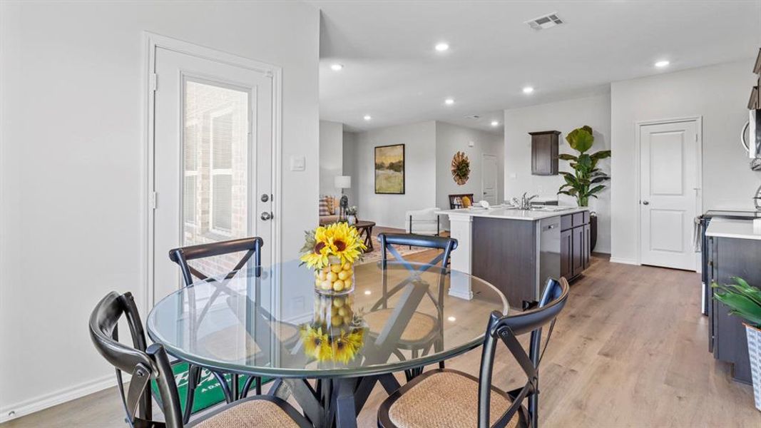 Dining area with light wood-style flooring and recessed lighting