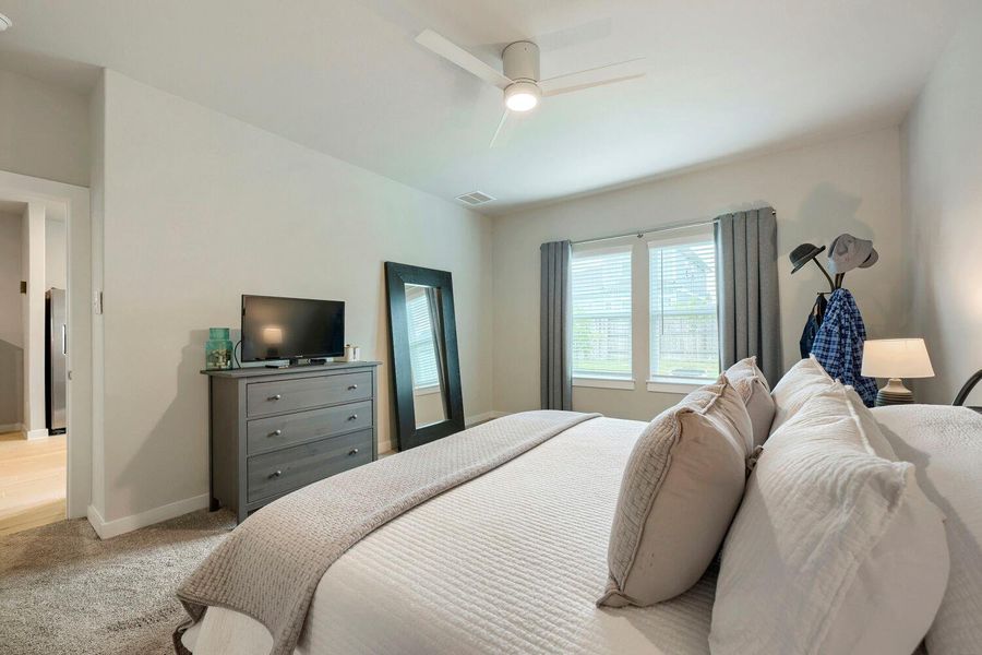 A comfortable bedroom with soft carpeting and ample natural light invites restful living. A comfortable bedroom with soft carpeting and ample natural light invites restful living.