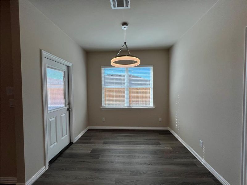 Unfurnished dining area with dark hardwood / wood-style flooring