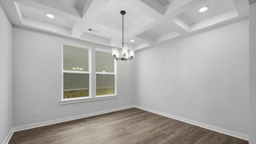 Dedicated laundry area with coffered ceiling and bright natural lighting from windows