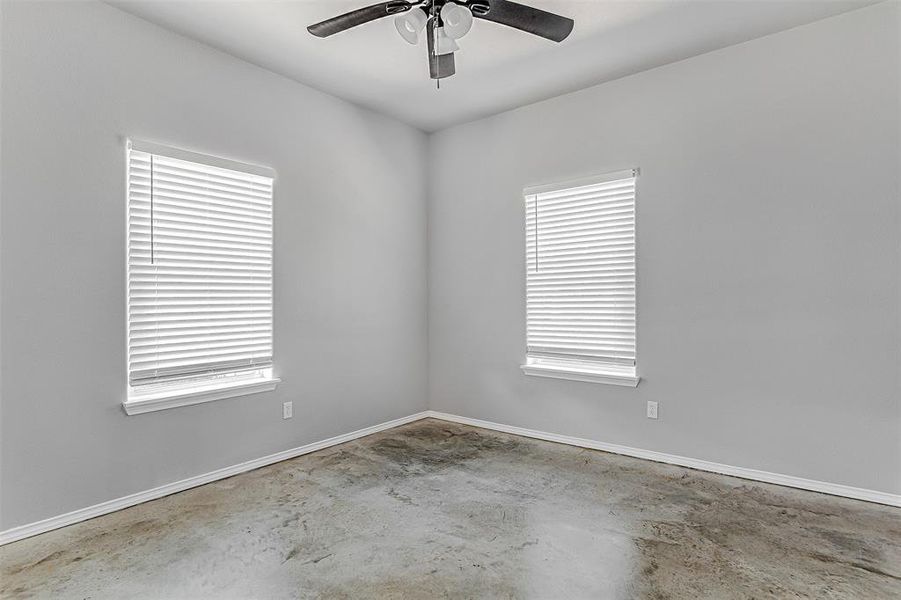 Empty room with ceiling fan and concrete floors