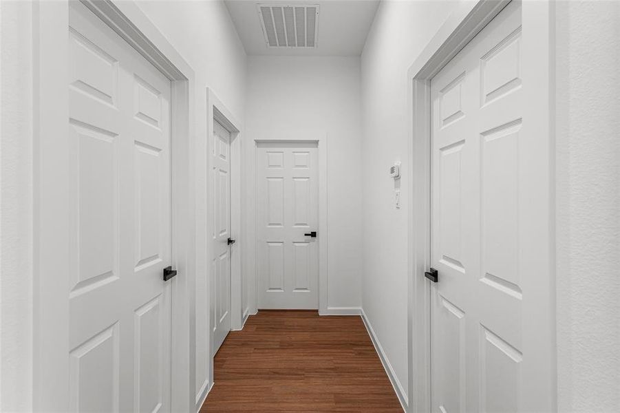 Corridor featuring dark wood-type flooring and baseboards