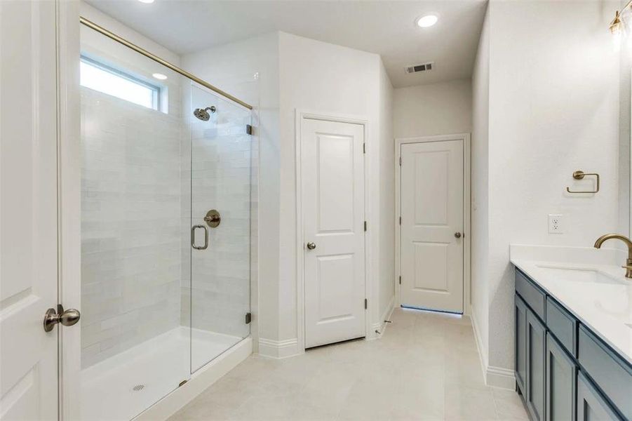 Full bath featuring a stall shower, double vanity, recessed lighting, and tile patterned flooring Full bath featuring a stall shower, double vanity, recessed lighting, and tile patterned flooring
