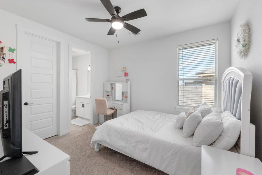 Bedroom 2 with visible vents, light colored carpet, ensuite bathroom, and a ceiling fan