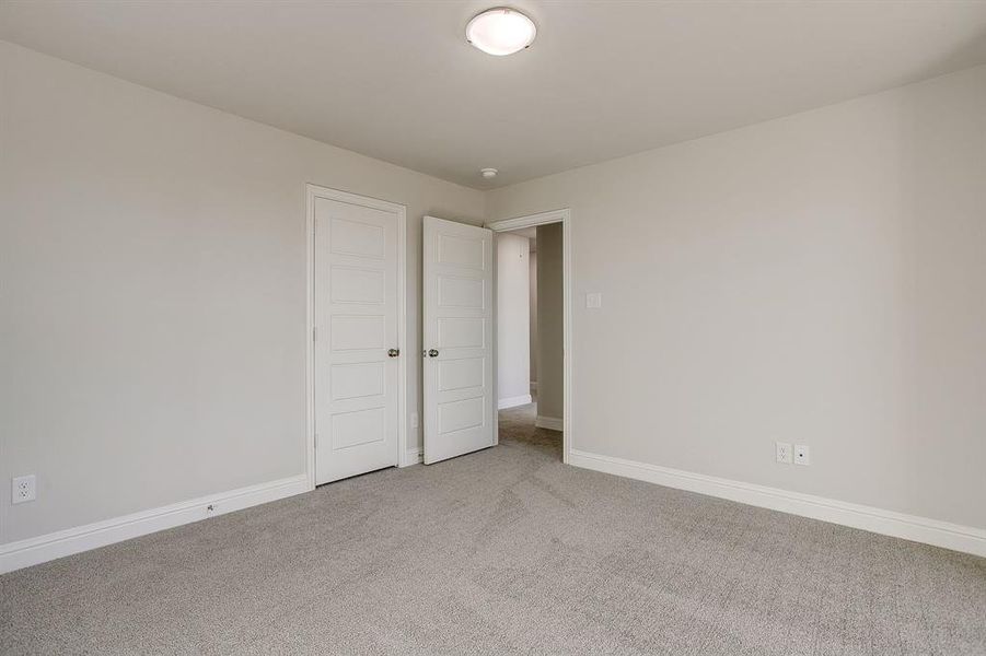 Unfurnished bedroom featuring baseboards and light carpet