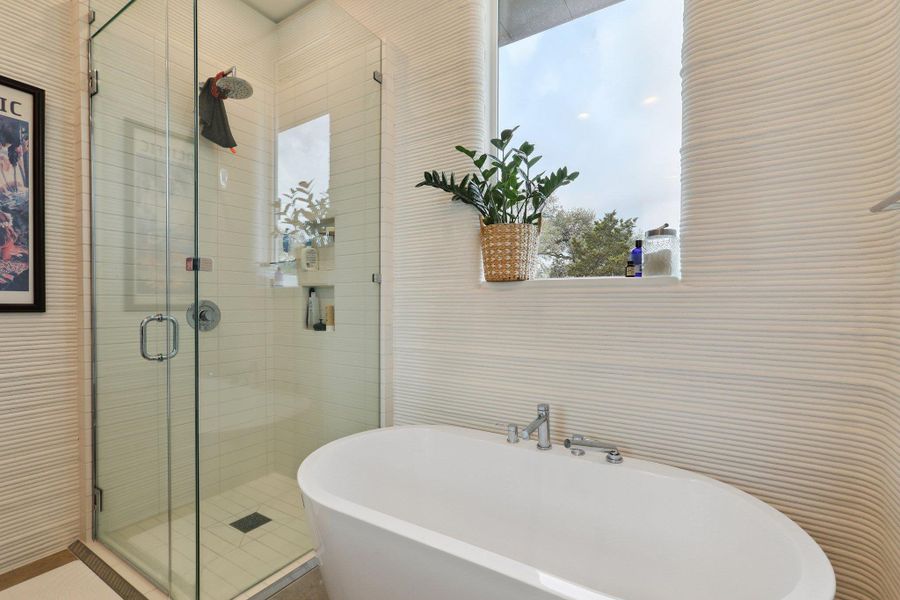 Bathroom featuring a stall shower and a freestanding tub