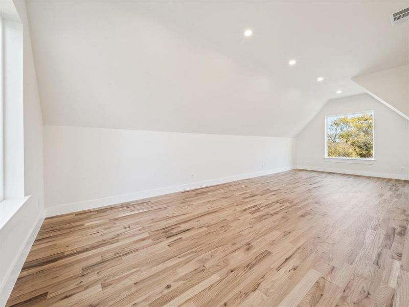 Bonus room featuring lofted ceiling and light wood-type flooring