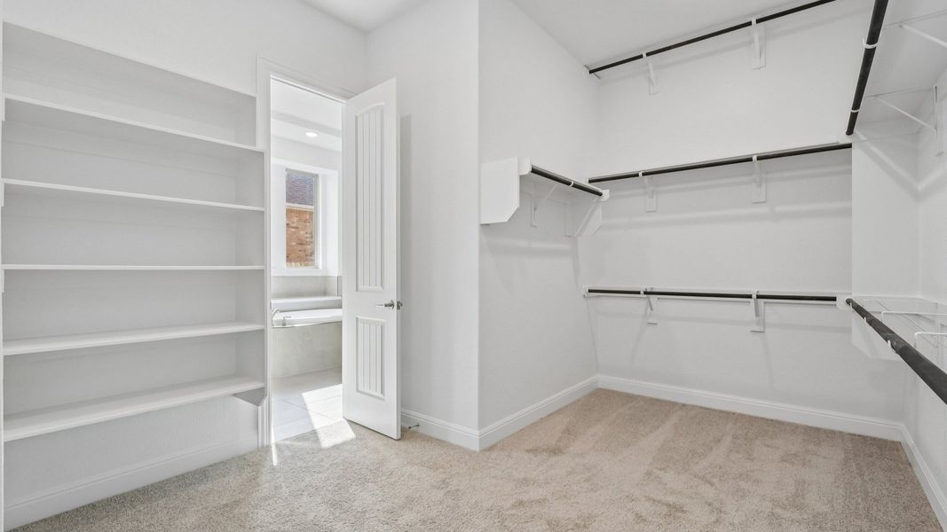 The walk-in closet in the Primary Bedroom of the Brown floorplan at Retreat at San Gabriel - Representative Image