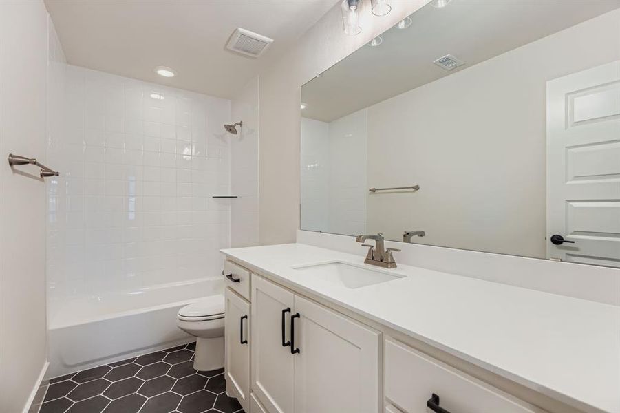 Full bathroom featuring vanity, shower / bath combination, dark tile patterned floors, and recessed lighting