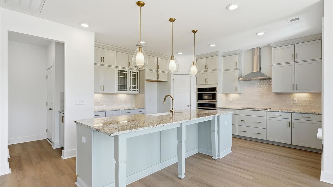 Highly skilled craftsmanship shines in this modern kitchen with pendant lighting and a central island focal point