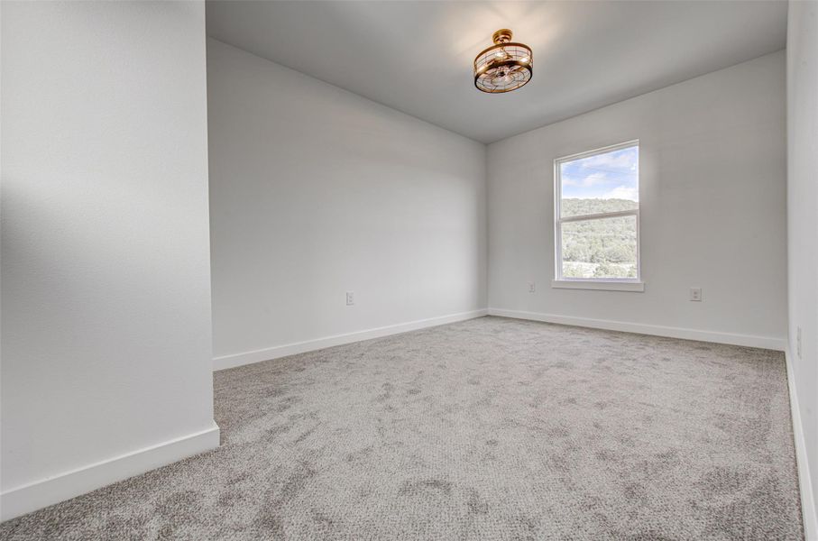Spare room featuring carpet and baseboards