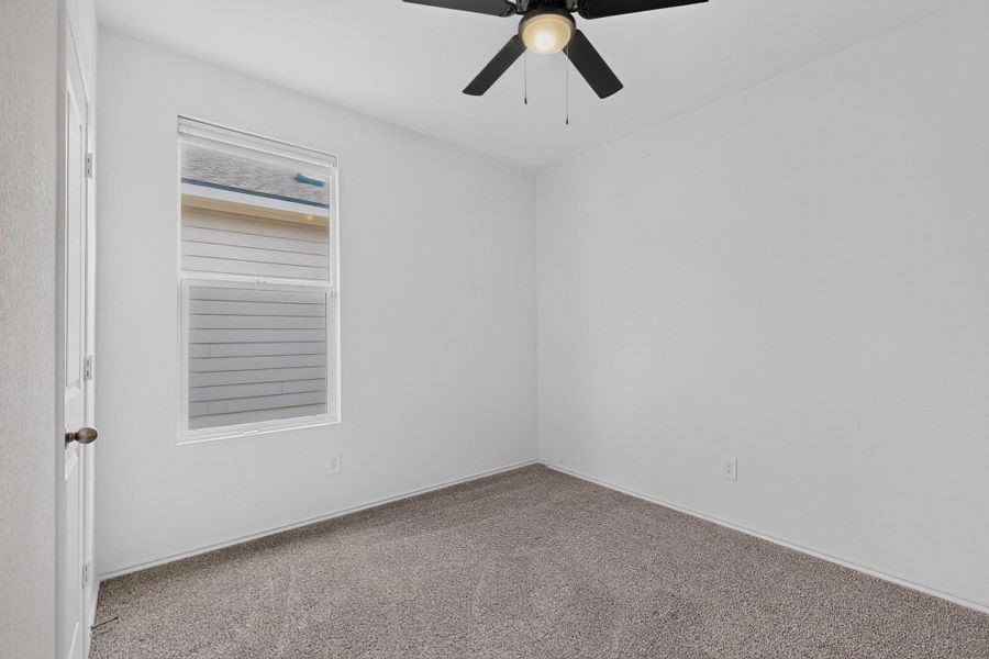 A window bathes this carpeted bedroom in soft natural light. A window bathes this carpeted bedroom in soft natural light.