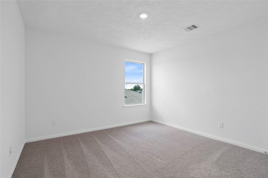 This secondary bedroom offers comfort and style with plush carpeting, neutral paint tones, recessed lighting, large window, and a generously sized closet. This secondary bedroom offers comfort and style with plush carpeting, neutral paint tones, recessed lighting, large window, and a generously sized closet.