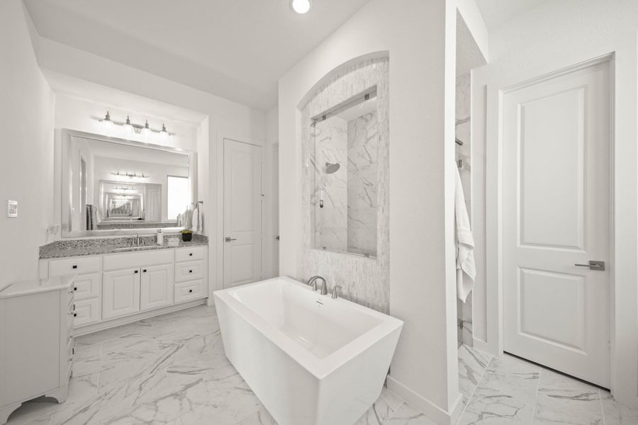 Both sides of the owner’s bath have cabinet storage and framed mirrors with an elegant five-light fixture. A linen closet and water closet sit to the left of the room.